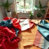 Bekijk populaire stoffen collectie met kleurrijke textielstalen op een houten tafel.