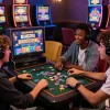 Friends enjoying situs gacor gaming session with vibrant slot machines and casual atmosphere