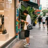 Stylish urban scene with a person exploring luxury 레플리카 fashion items in a trendy shopping district.
