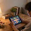 Engaged player enjoying judi slot game on a tablet in a cozy home setting, illustrating mobile gambling experience