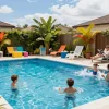 Dolphin Pool Services maintaining a family-friendly pool environment with kids playing and adults relaxing.