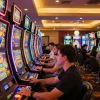 Players enjoy slot gacor machines in a vibrant casino, celebrating wins and engaging with colorful displays.