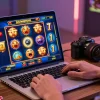 Engaged player at laptop enjoying slot deposit 5k gaming, vibrant graphics and energetic atmosphere.