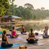 Yoga teacher trainings Sri Lanka with aspiring instructors practicing asanas at sunrise on Koggala Lake.